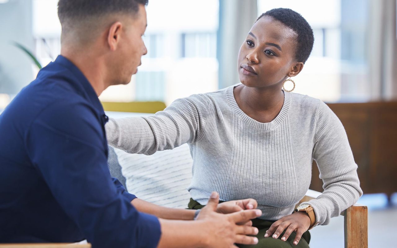 Black woman, office and console man in stress, panic or talking with mental health support in workplace. Professional, businesswoman and care for employee, coworker or management of work pressure.